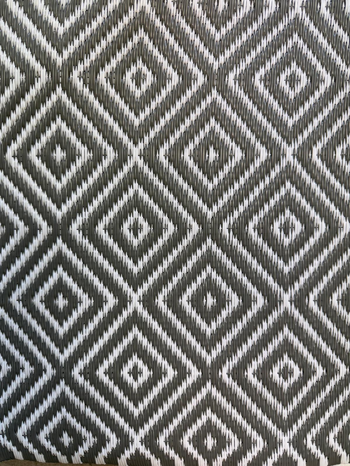 Green diamond-pattern polypropylene flooring with curved folded corner showing texture and edge