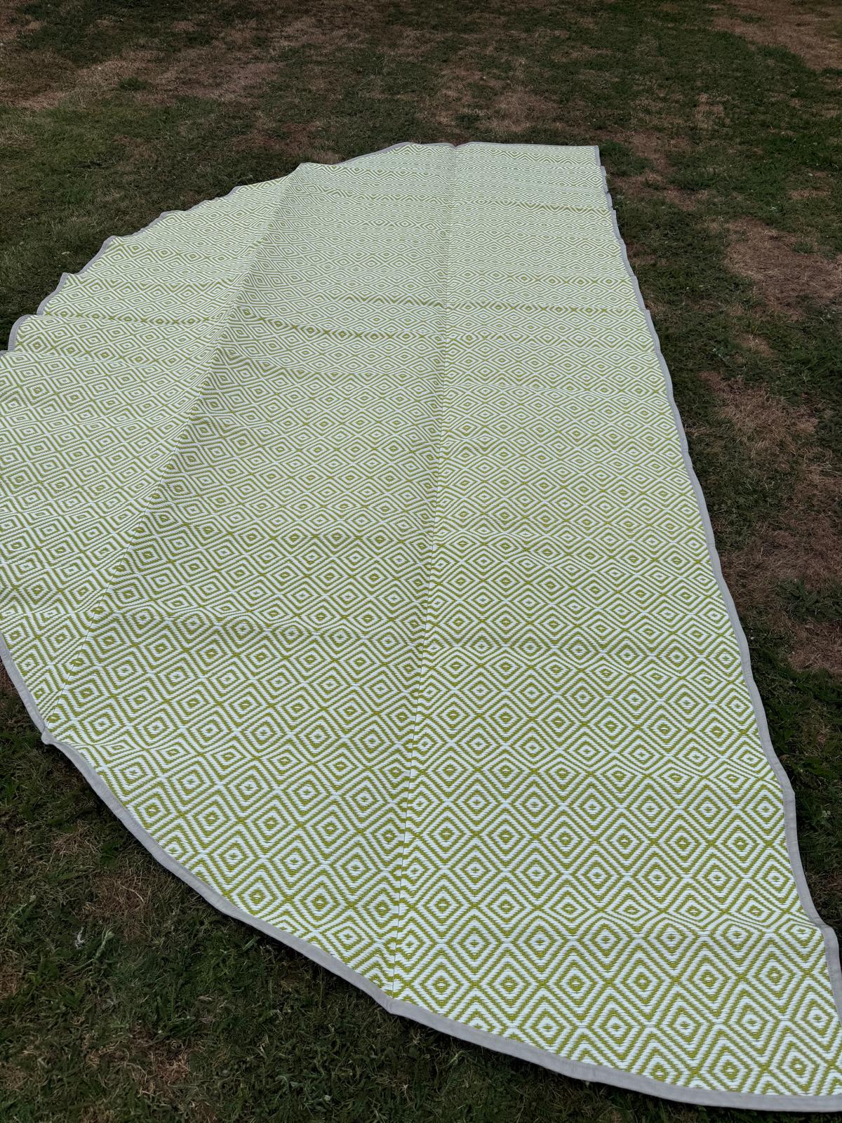 Green diamond-pattern polypropylene flooring laid outdoors in a wide semi-circle shape showing full surface design