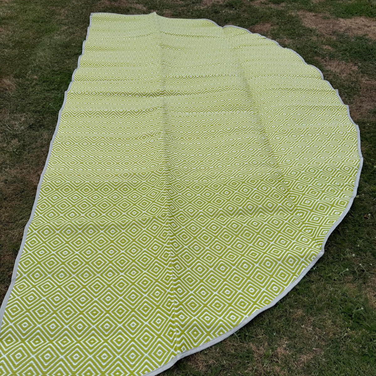 Wide close-up of green diamond-pattern polypropylene flooring with woven texture and edging