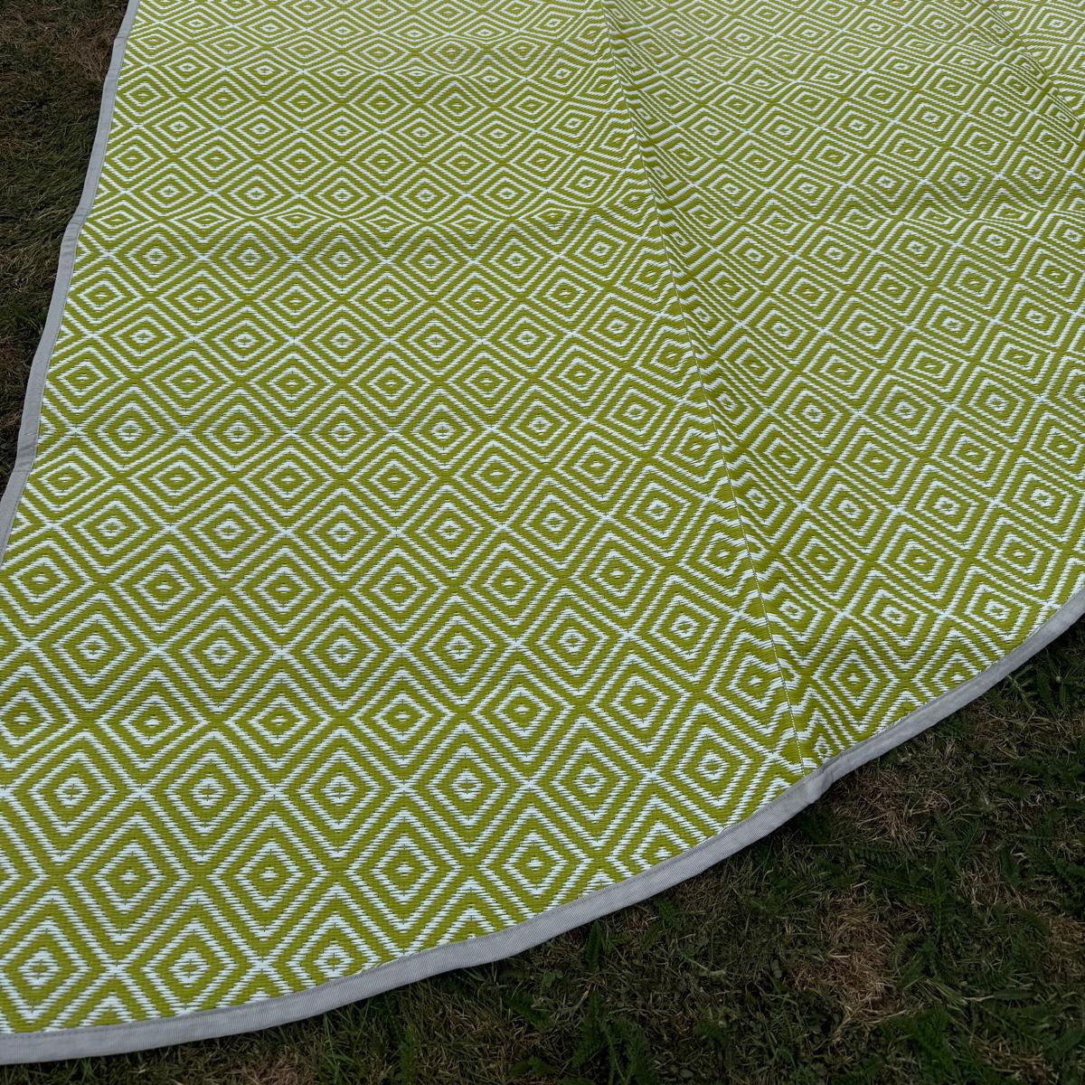 Angled view of green diamond-pattern polypropylene flooring with detailed weave and edging