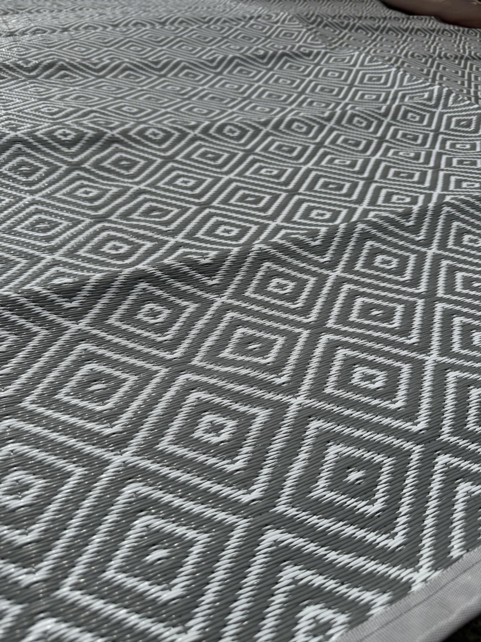 Close-up of a gray and white geometric patterned rug.