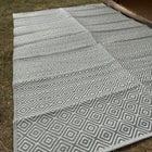 Gray and white geometric patterned rug on grass