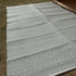 Gray and white geometric patterned rug on grass