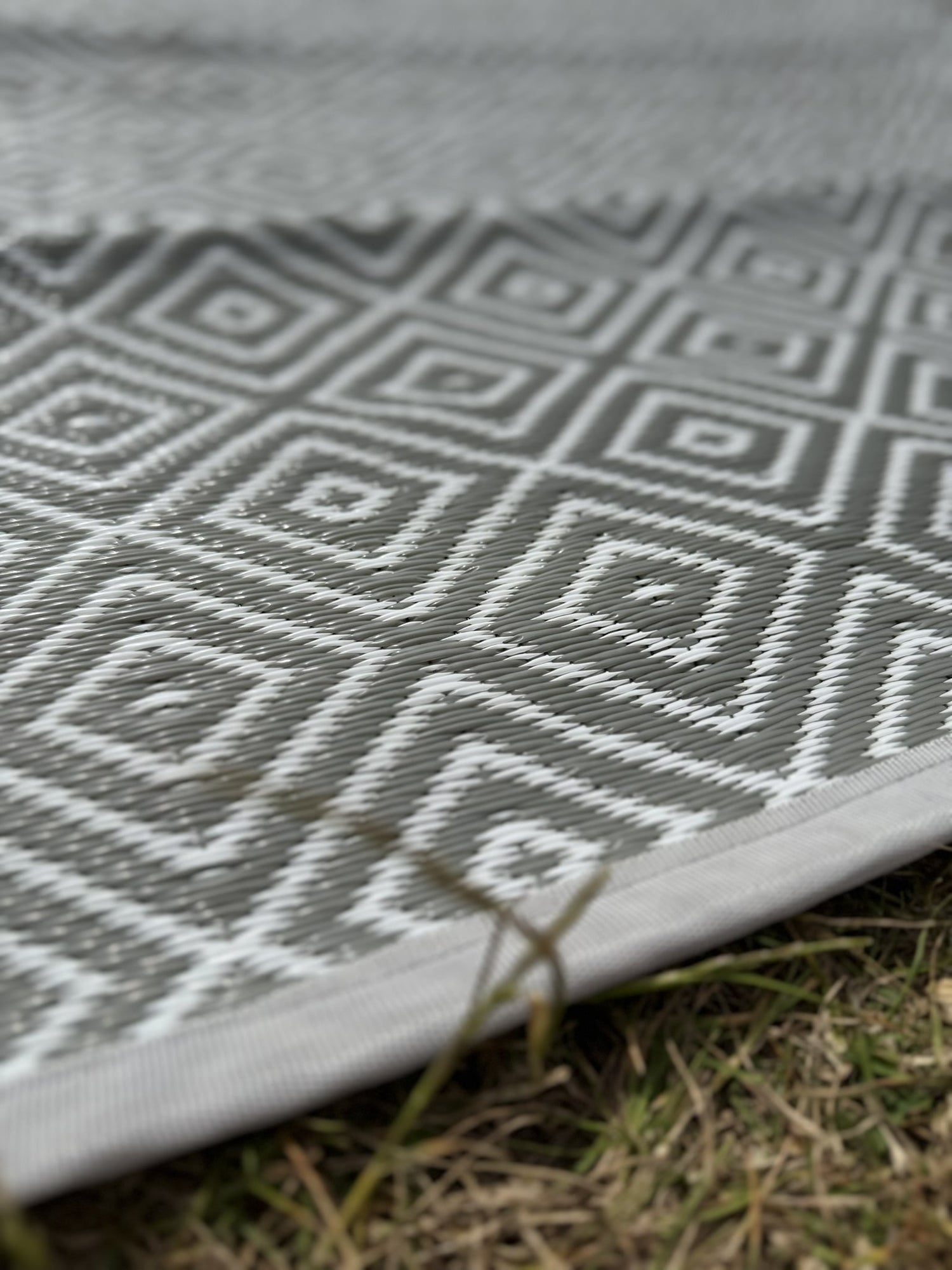 Gray and white geometric patterned mat on grass