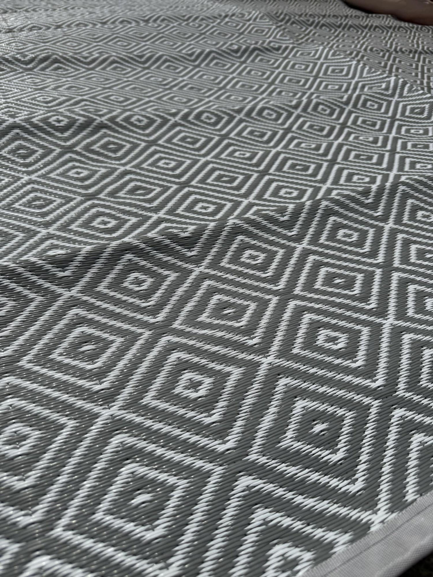 Close-up of a gray and white geometric patterned rug.